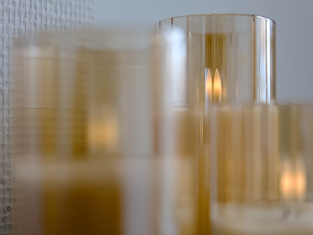 Glowing candles in elegant amber glass holders